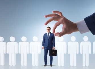 A large hand selecting a businessman from a group of candidate silhouettes, symbolizing recruitment and talent selection.